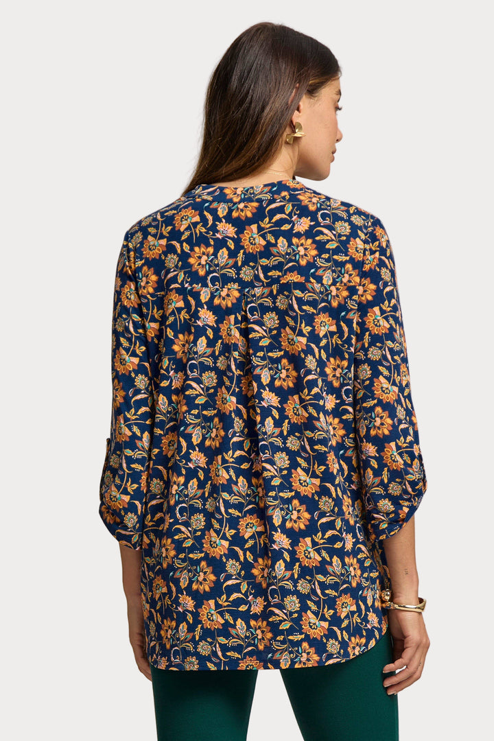 Woman wearing a floral patterned blouse with a neutral background