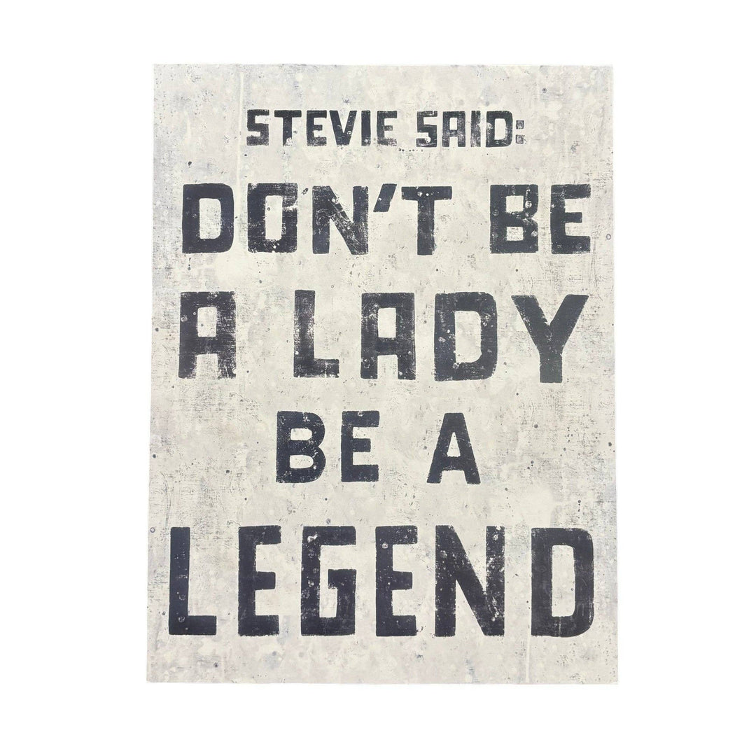 A poster with a black and white color scheme featuring the text 'Stevie Said: Don't Be a Lady Be a Legend' in stylized font on a distressed background.