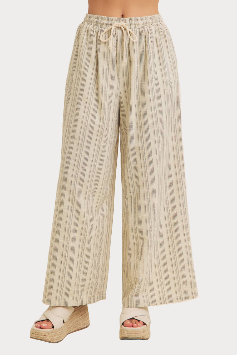 A model wearing striped wide-leg pants with a comfortable elastic waistband, in a standing pose against a plain background.