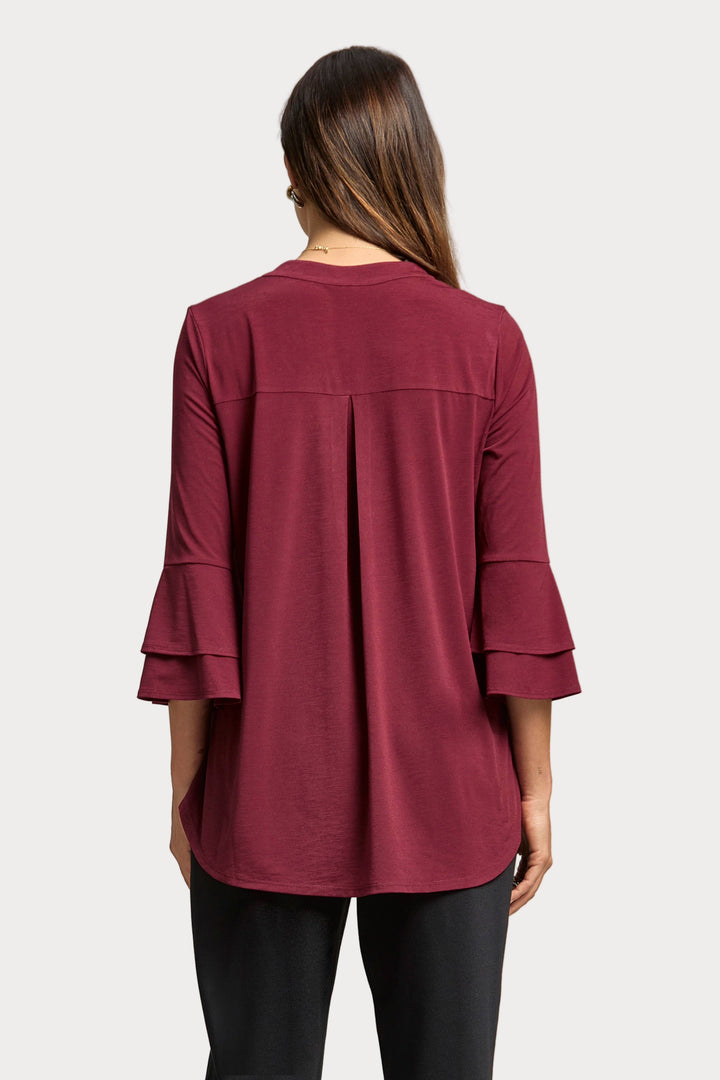 Maroon long-sleeve top worn by a person on a plain background