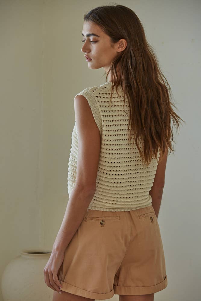 Natural crochet knit sleeveless vest with round neck, paired with shorts for a relaxed summer outfit.