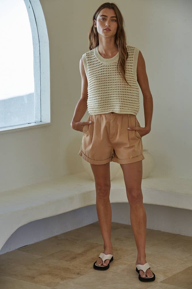 Natural crochet knit sleeveless vest with round neck, paired with shorts for a relaxed summer outfit.