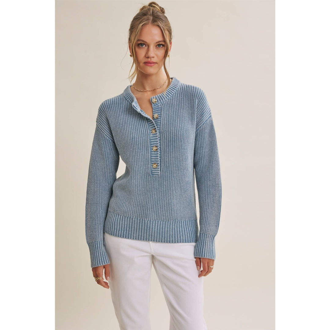 Woman wearing The Sutton mineral-wash blue Henley sweater with white pants