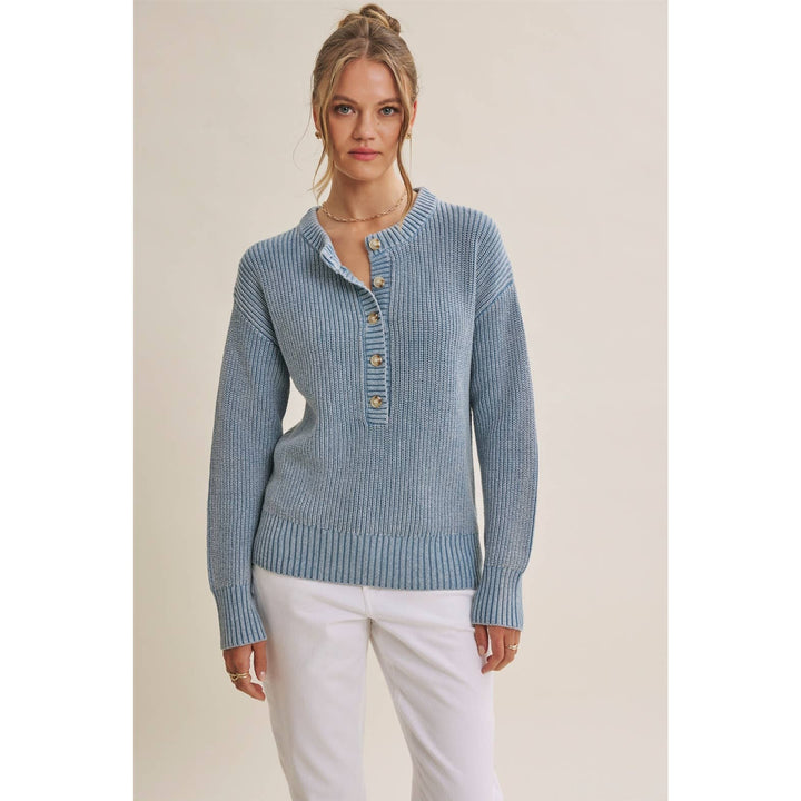Woman wearing The Sutton mineral-wash blue Henley sweater with white pants