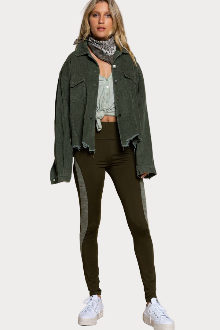 A woman models a relaxed-fit, olive green corduroy jacket with a raw, frayed hem over a t-shirt and pants.

