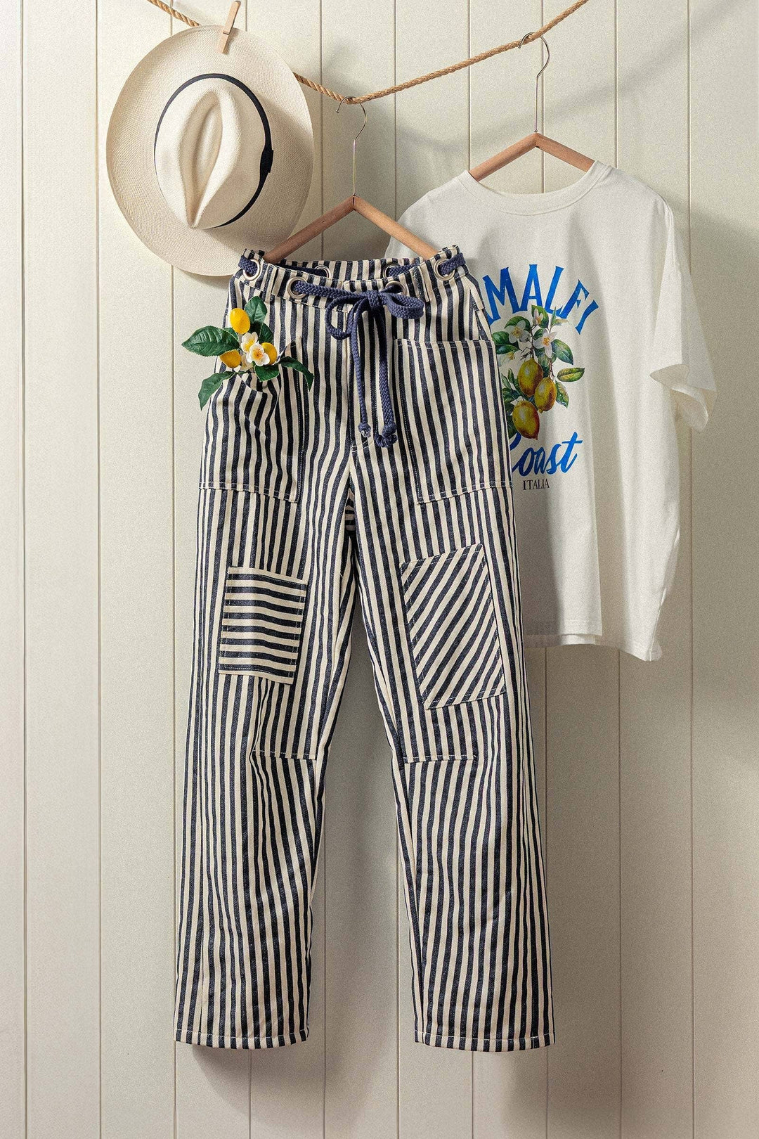 Striped pants and a white shirt with text and graphics on a wooden background