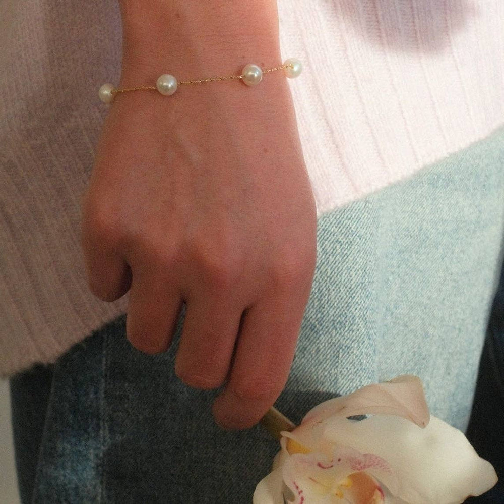 gold bracelet with floating freshwater pearls on delicate chain shown on model 