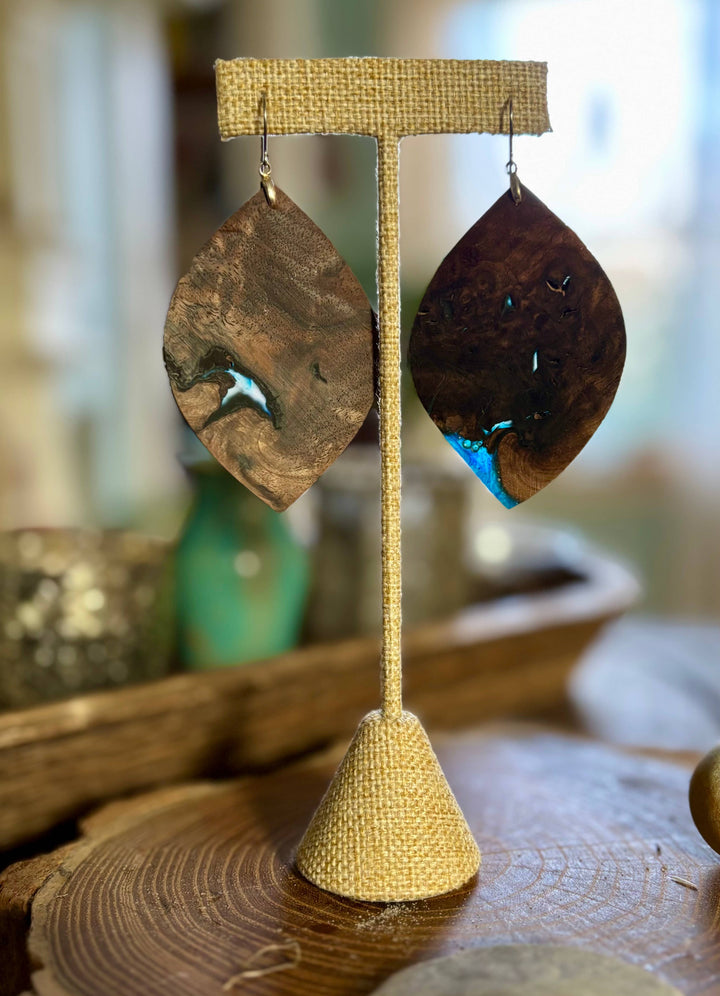 Handcrafted midnight walnut wood and blue resin statement earrings with natural grain patterns and hypoallergenic stainless-steel hardware.