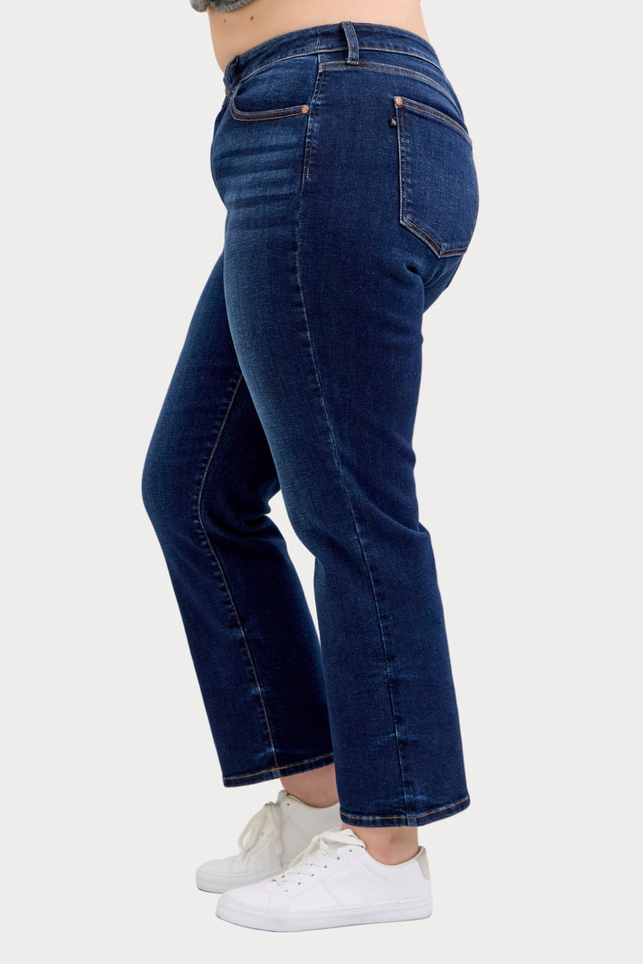 Model wearing Judy Blue mid-rise dark wash straight jeans with a short 30-inch inseam left facing side view