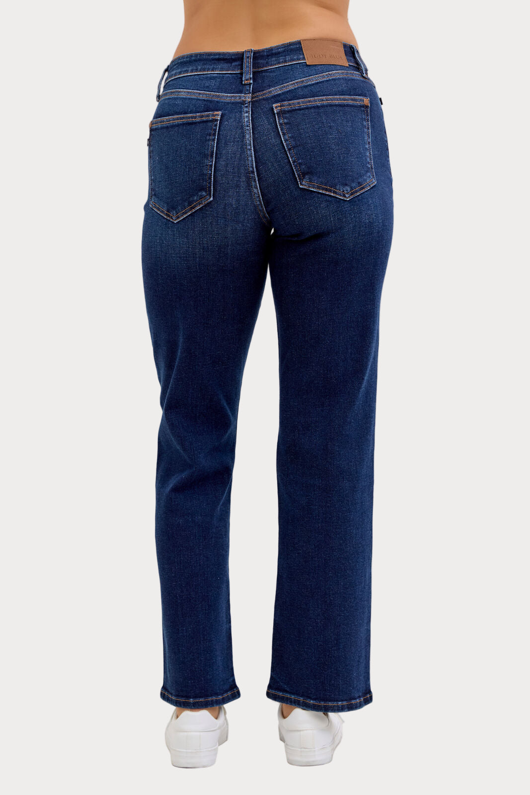 Model wearing Judy Blue mid-rise dark wash straight jeans with a short 30-inch inseam