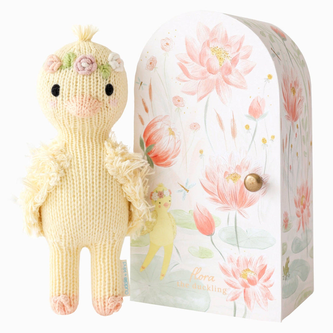 Knitted doll with floral design packaging on a white background