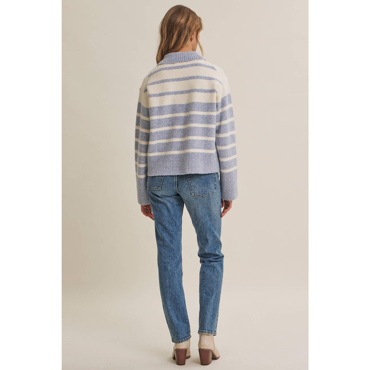 Woman wearing The Marlowe ice blue and ivory striped brushed Henley sweater with blue jeans
