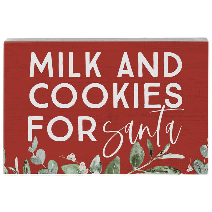 red wood art block with “Milk and Cookies for Santa” text and greenery accents