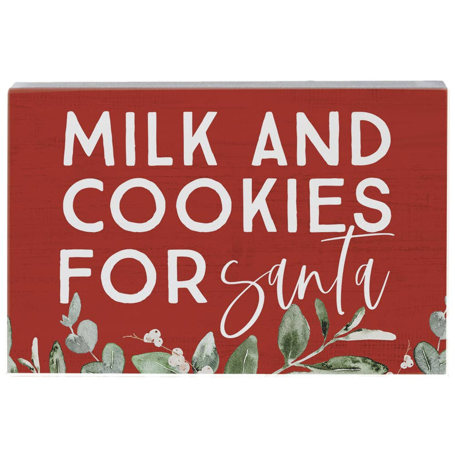 red wood art block with “Milk and Cookies for Santa” text and greenery accents