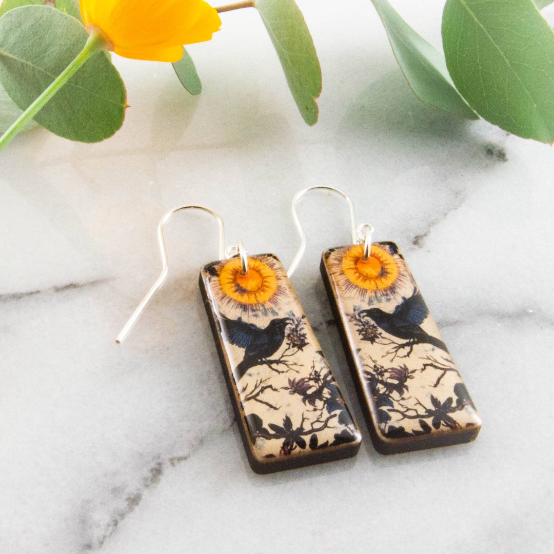 Moody vintage raven wood earrings with golden sun botanical illustration and sterling silver ear wires