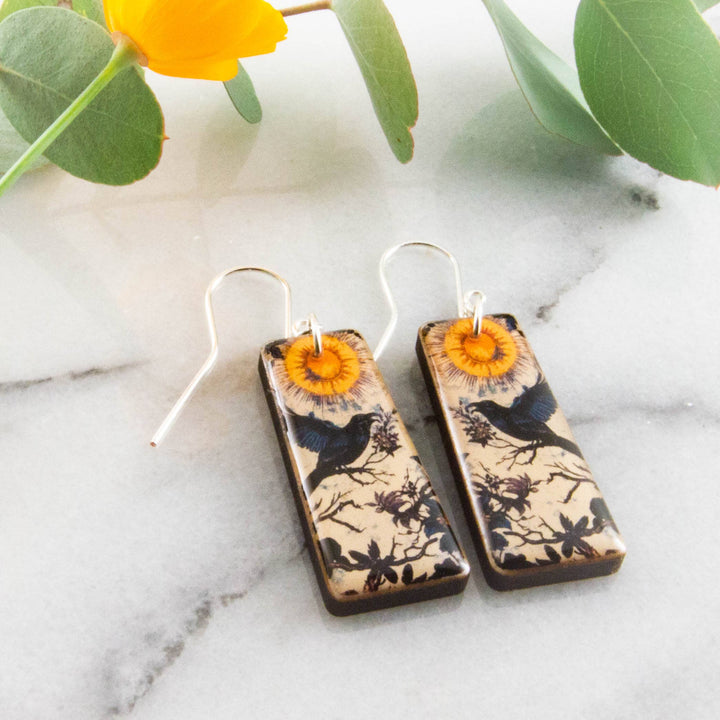 Moody vintage raven wood earrings with golden sun botanical illustration and sterling silver ear wires
