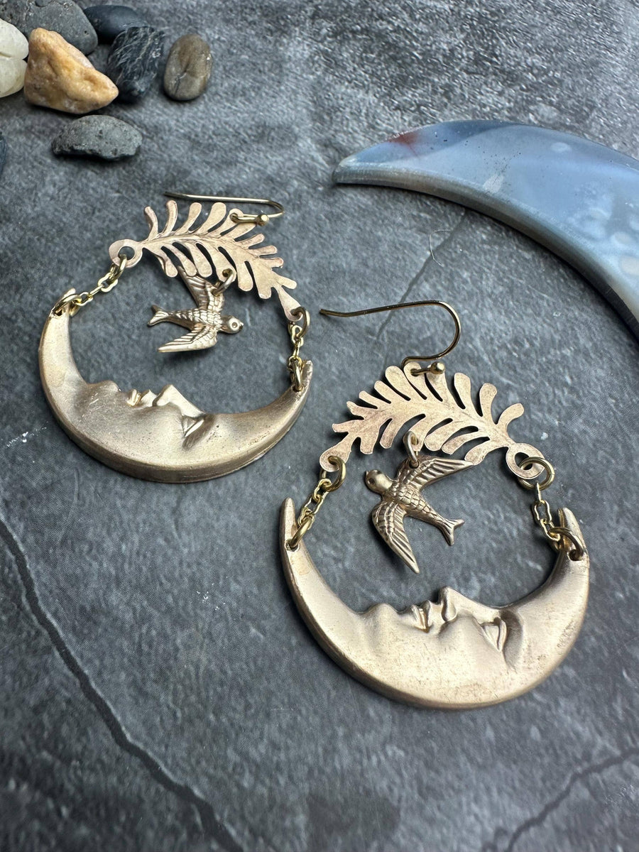 Luna Messenger Earrings with brass crescent moon faces, flying birds and botanical branch details