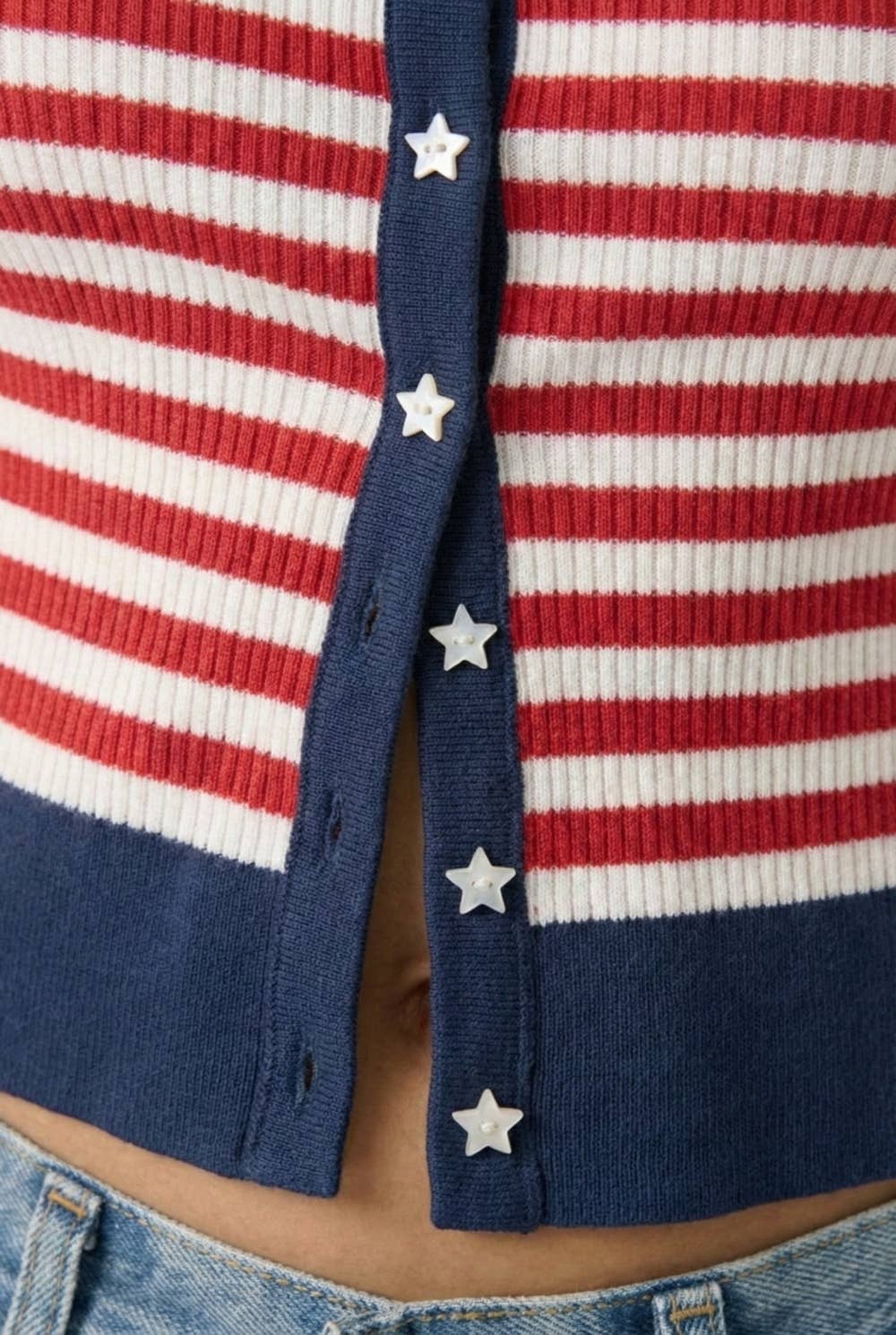 Close up detail shot of red and white cardigan with navy trim & white star buttons