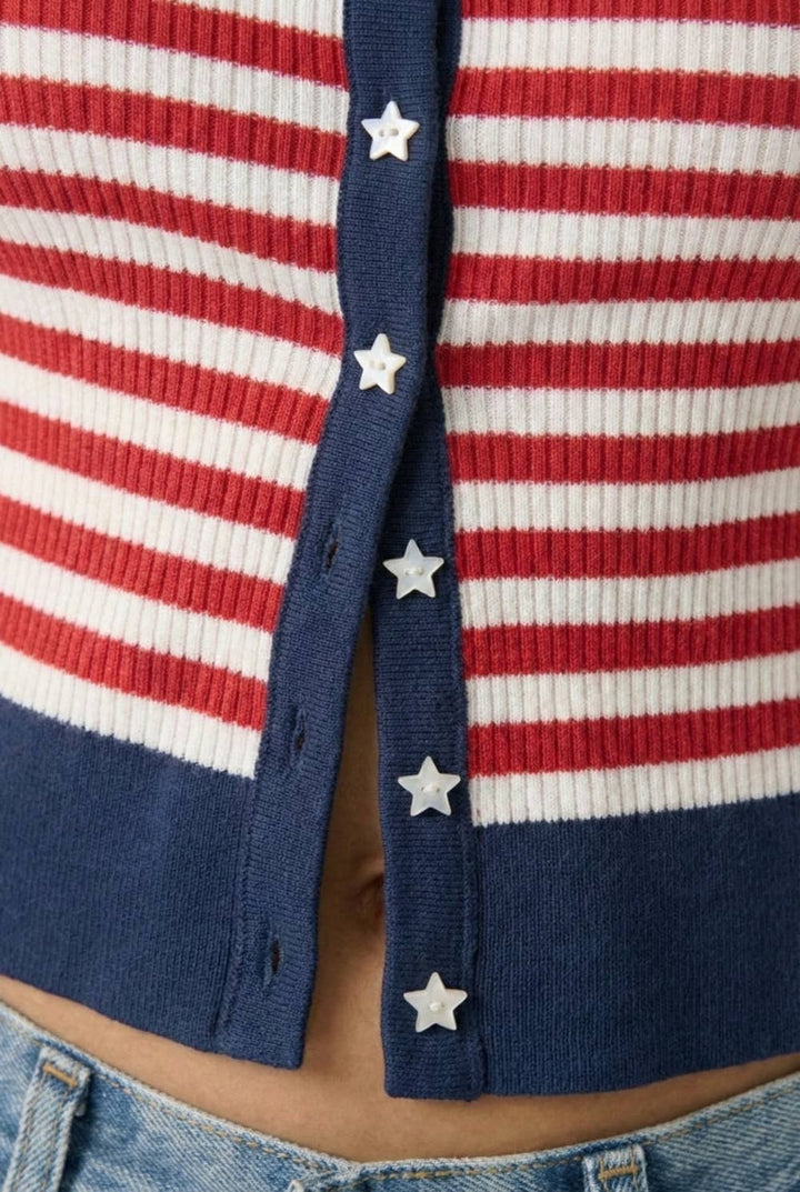 Close up detail shot of red and white cardigan with navy trim & white star buttons