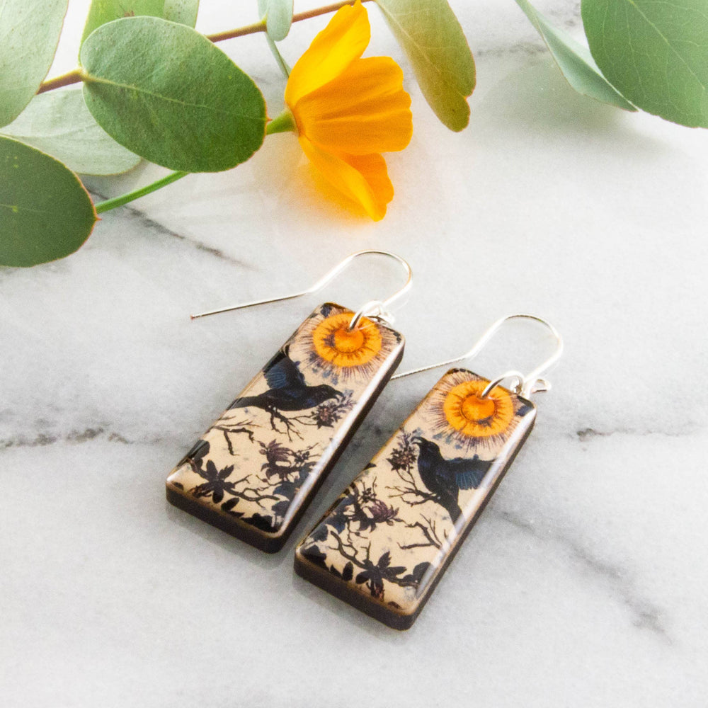 Moody vintage raven wood earrings with golden sun botanical illustration and sterling silver ear wires