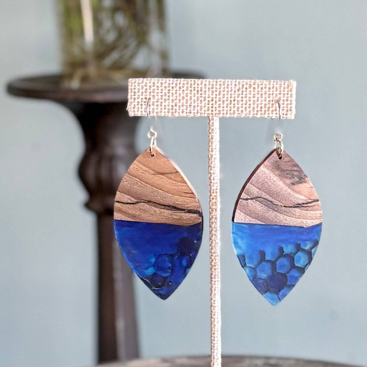 Handcrafted Indigo Hive Wood Earrings featuring natural wood grain and deep indigo resin with honeycomb detailing and hypoallergenic stainless-steel hooks.