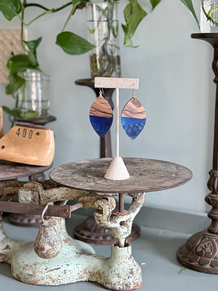 Handcrafted Indigo Hive Wood Earrings featuring natural wood grain and deep indigo resin with honeycomb detailing and hypoallergenic stainless-steel hooks.