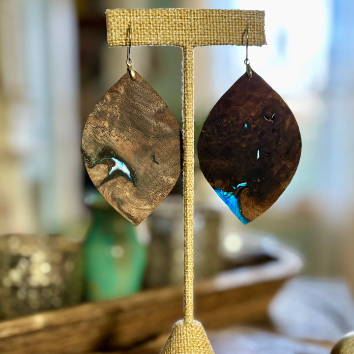 Handcrafted midnight walnut wood and blue resin statement earrings with natural grain patterns and hypoallergenic stainless-steel hardware.
