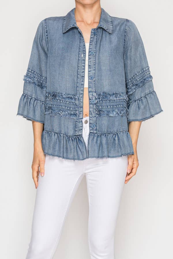 Denim top with ruffled details worn by a person on a white background