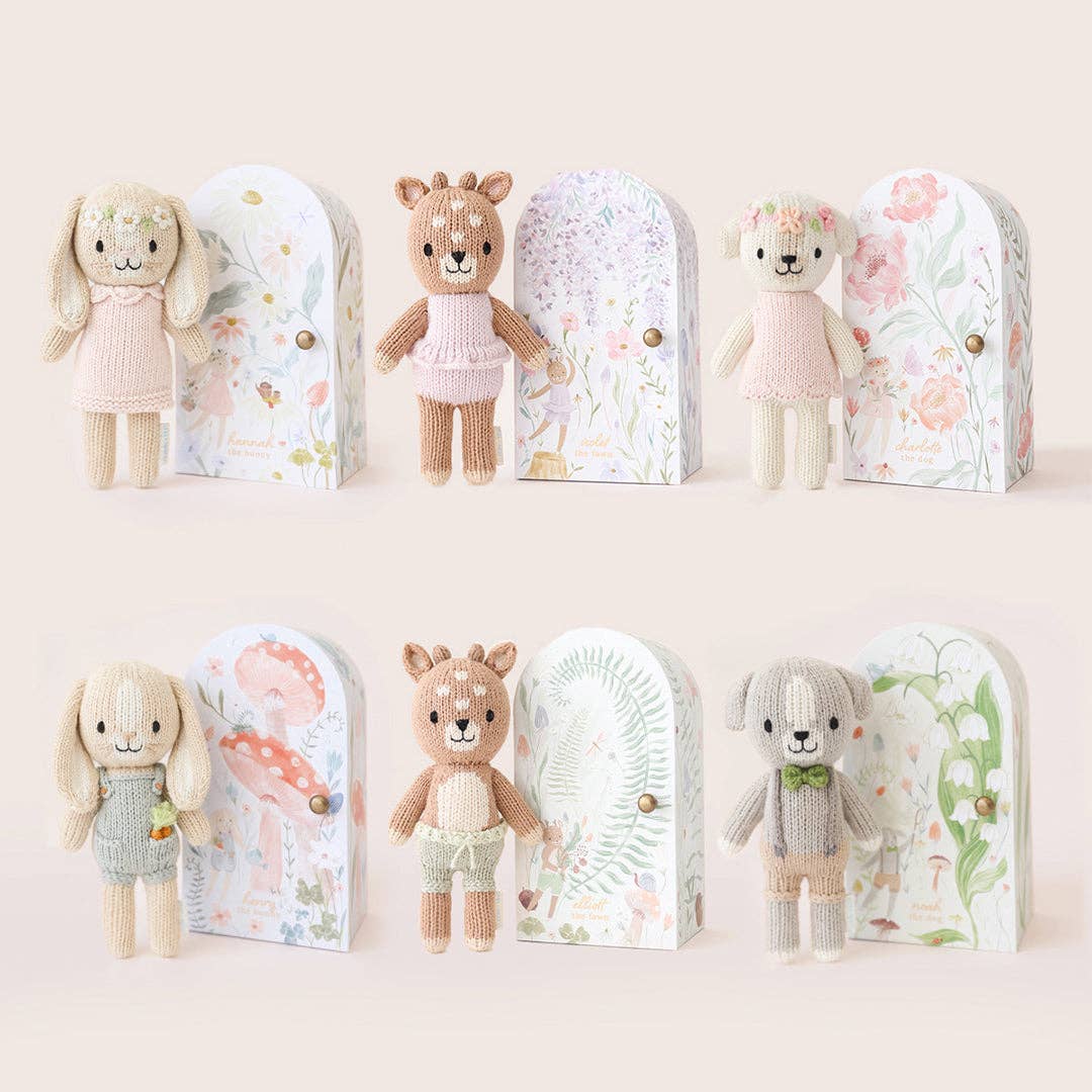 Set of small stuffed animals in decorative boxes on a light background