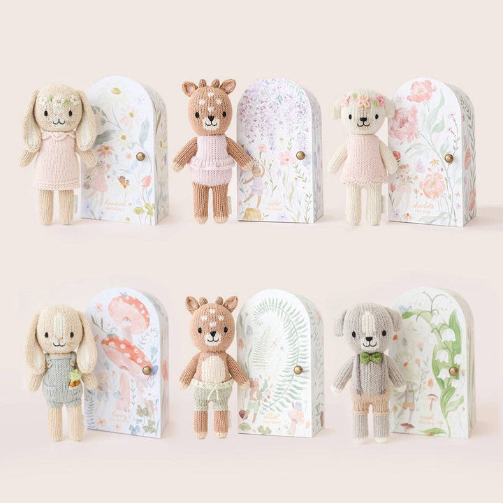 Set of small stuffed animals in decorative boxes on a light background