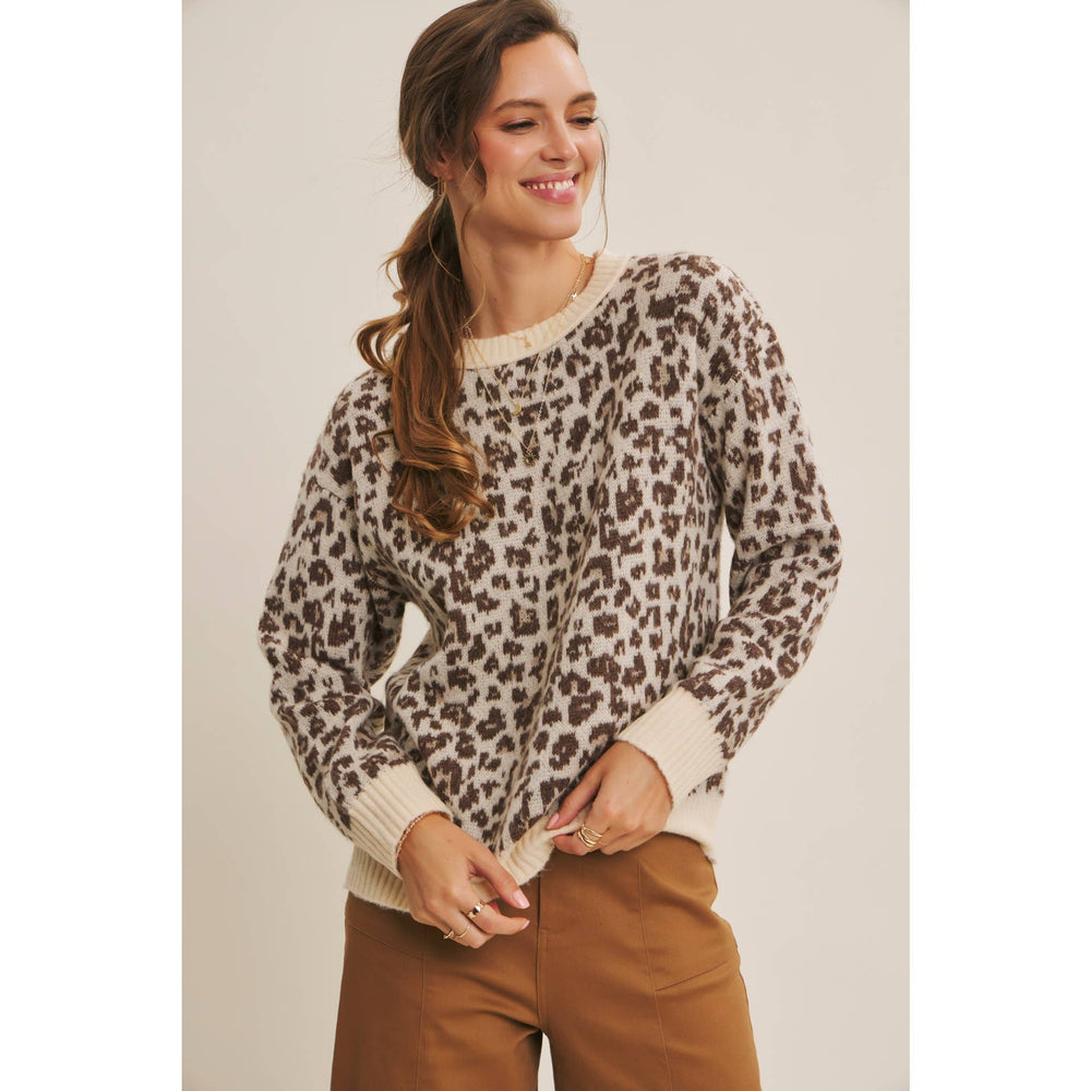Woman wearing a leopard print sweater with a plain background