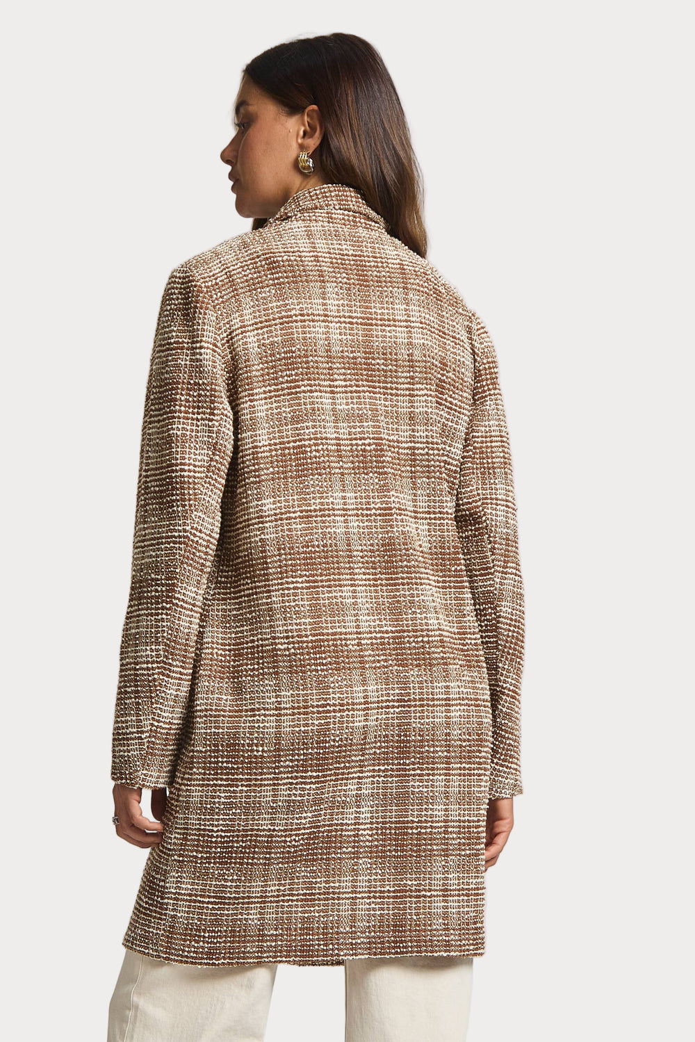 Woman wearing a brown checkered coat on a white background