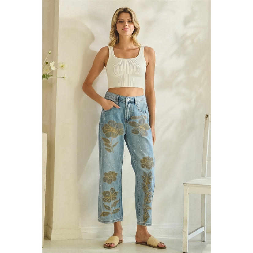Woman wearing a white top and floral jeans in a room with a neutral color scheme.