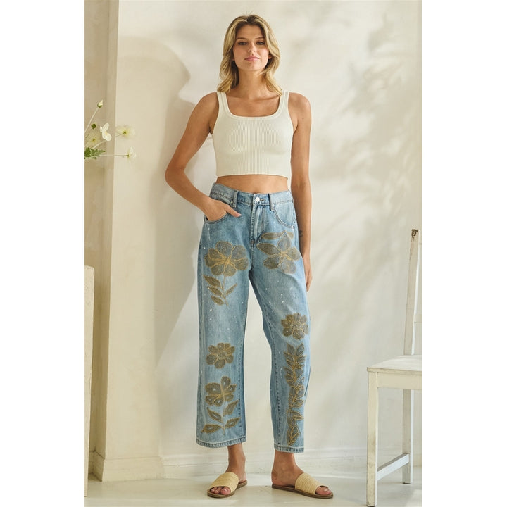 Woman wearing a white top and floral jeans in a room with a neutral color scheme.