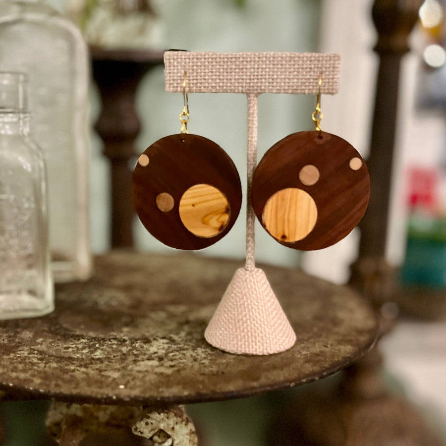 Wooden earrings on a stand with a rustic background