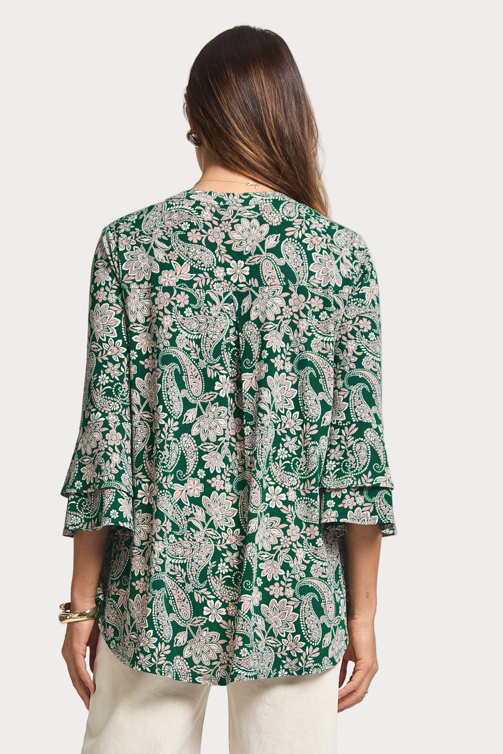 Woman wearing a green floral blouse on a white background