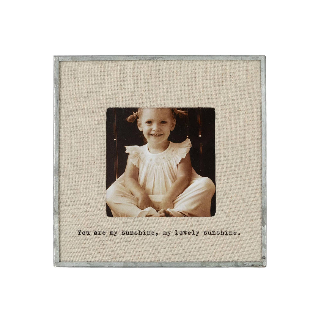 Linen and metal picture frame with 'You are my sunshine, my lovely sunshine' text. Shown on a white background