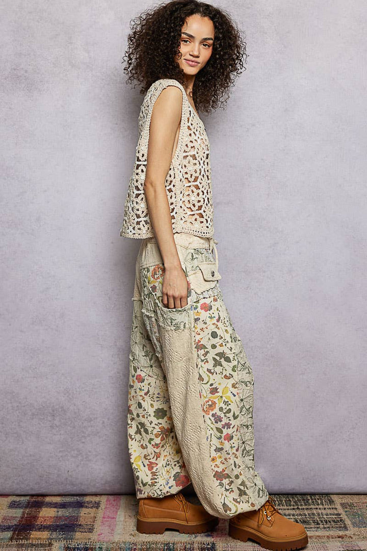 Model wearing The Cottage Bloom Patchwork Joggers by POL featuring vintage-inspired floral patchwork, textured jacquard details, oversized utility pockets, and a relaxed bohemian silhouette.