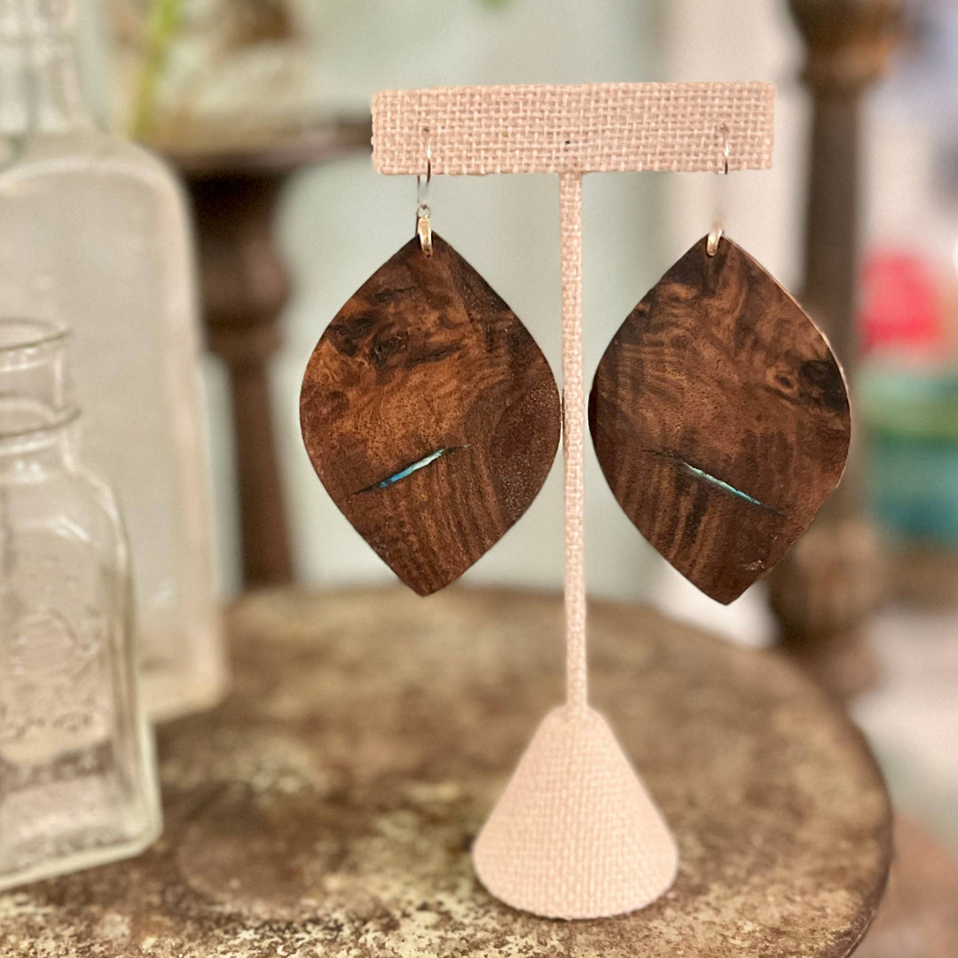 Wooden earrings on a display stand with a blurred background