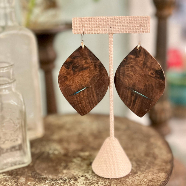 Wooden earrings on a display stand with a blurred background