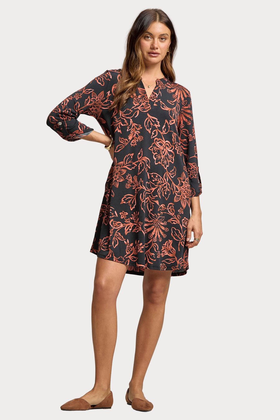 Woman wearing a patterned dress on a plain background