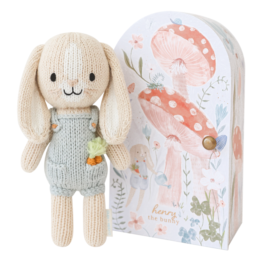 Knitted bunny toy with a floral-themed packaging box on a white background