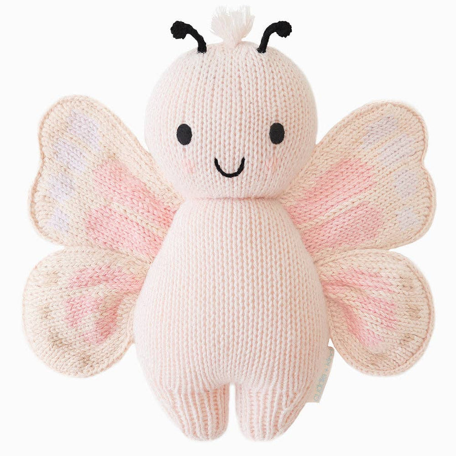 Knitted butterfly toy with pink and white wings on a white background