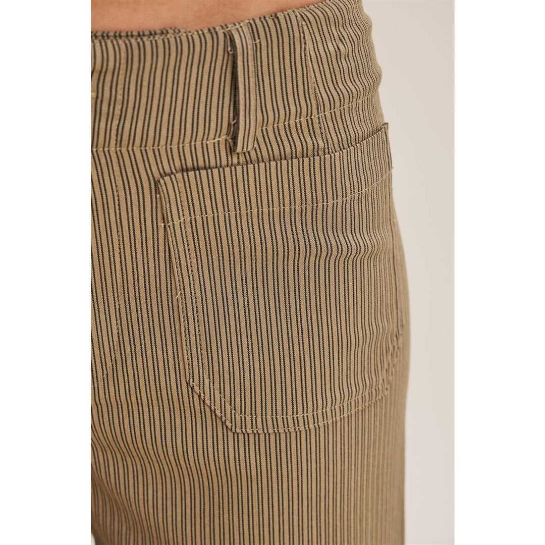 Close-up of the front waistband and pocket of a pair of pants in a beige and brown vertically striped pant.