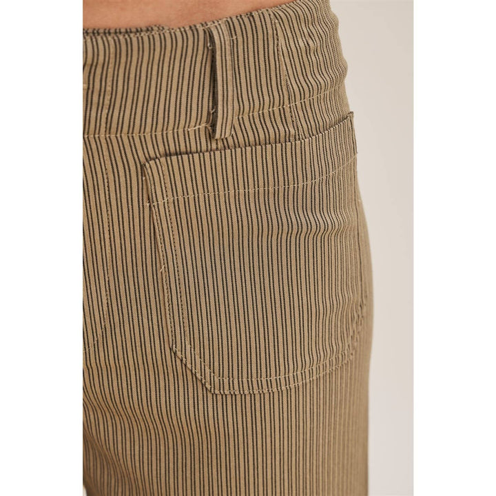 Close-up of the front waistband and pocket of a pair of pants in a beige and brown vertically striped pant.