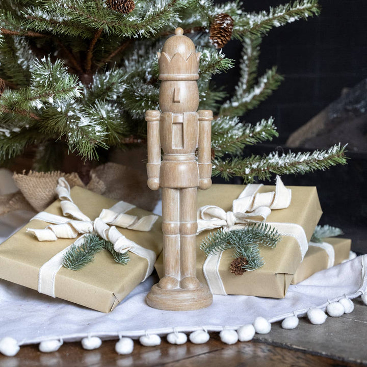 16" resin nutcracker with carved wood look. A classic neutral holiday accent for mantels, shelves, and festive displays.
