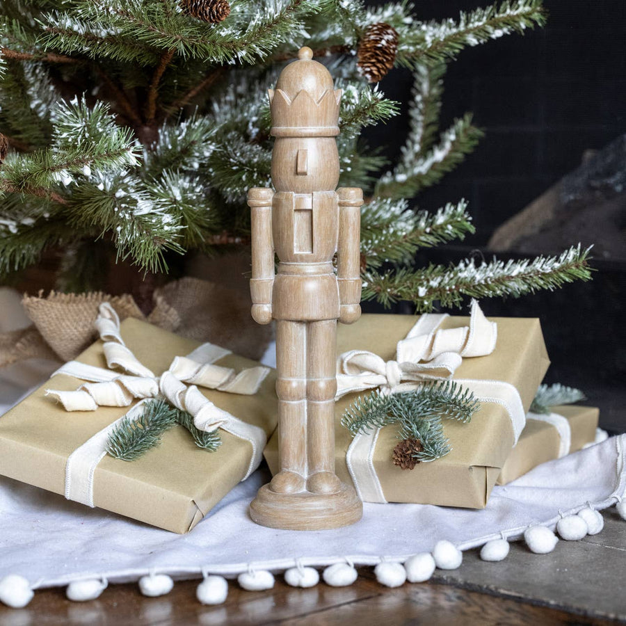 16" resin nutcracker with carved wood look. A classic neutral holiday accent for mantels, shelves, and festive displays.
