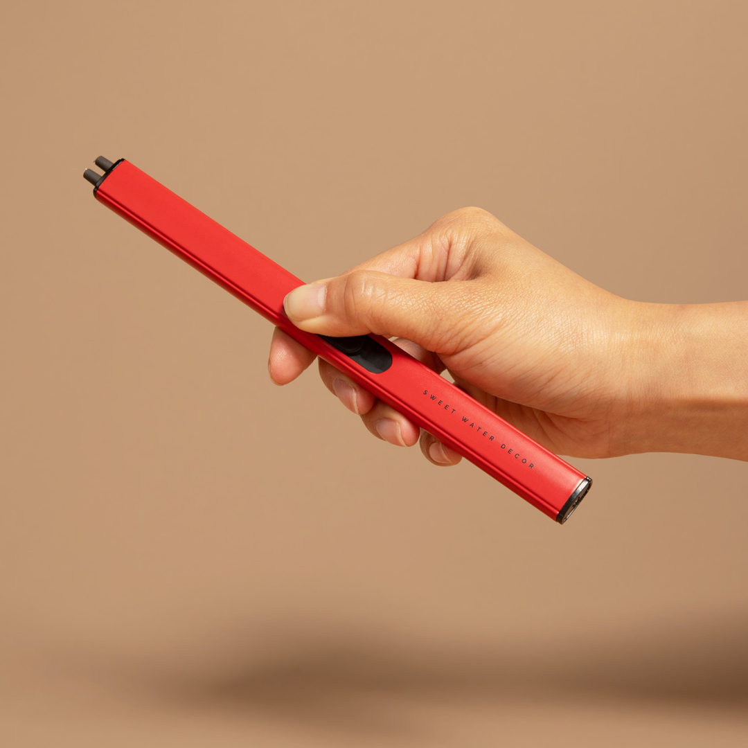 Hand holding a red lighter against a beige background