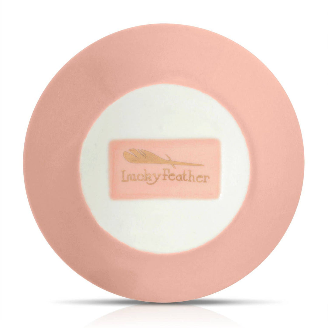 Pink round product with 'Lucky Feather' logo, back of dish, on a white background
