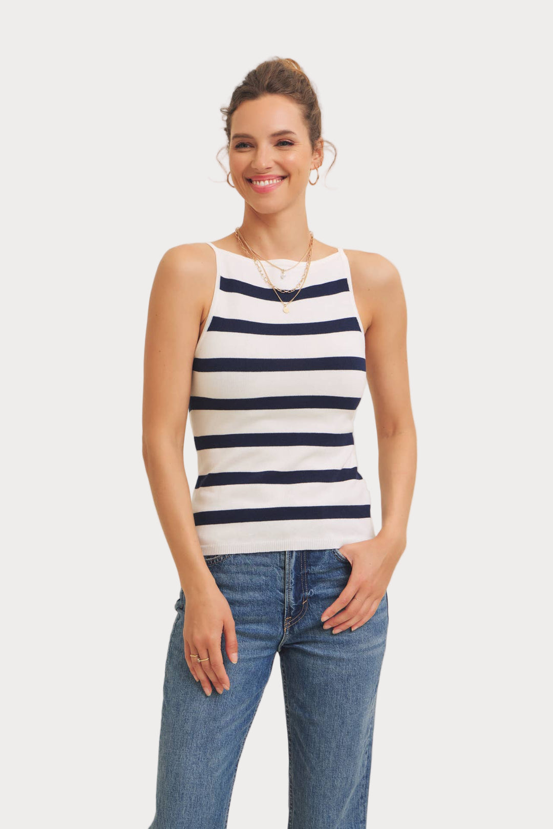 Woman wearing a striped tank top and jeans on a white background